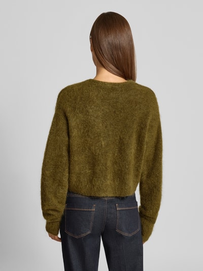 Frauenmodel trägt Strickjacke aus Woll-Mohair-Mix Modell 'debbie' von Gestuz, olivgrün, lockere Passform, gerippte Abschlüsse, Ganzkörperansicht Rückansicht.