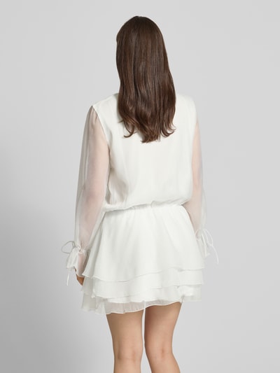 Frauenmodel trägt Minikleid mit Rüschen und Schnürung von Gina Tricot in A-Linie und Semitransparenz, Rückenlänge 86 cm, Ganzkörperansicht Rückansicht.