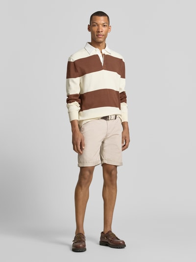 Männermodel trägt Bermudas mit Gürtel und Eingrifftaschen von MCNEAL aus Baumwoll-Mix mit Stretch-Anteil in Beige, Straight Fit, Ganzkörperansicht von vorne.
