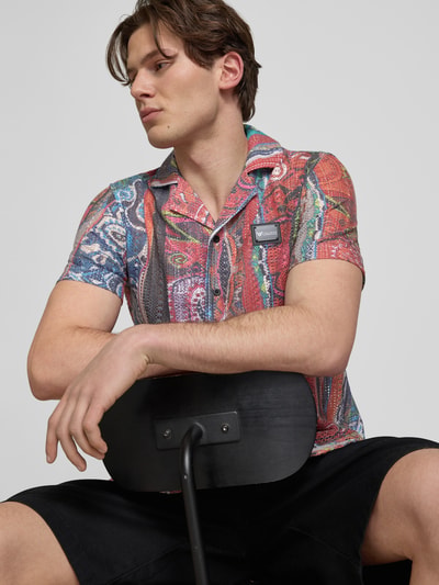 Męski model nosi Slim Fit Freizeithemd in Strick-Optik Modell 'resort' od COLUCCI, kolorowy wzór, materiał z bawełną, krój slim fit, kołnierz rewers, krótki rękaw, pełna listwa guzikowa, długość tyłu w rozmiarze M: 71 cm, szerokość ramion w rozmiarze M: 46 cm, długość rękawa w rozmiarze M: 11 cm, ujęcie: zbliżenie górnej części ciała z przodu