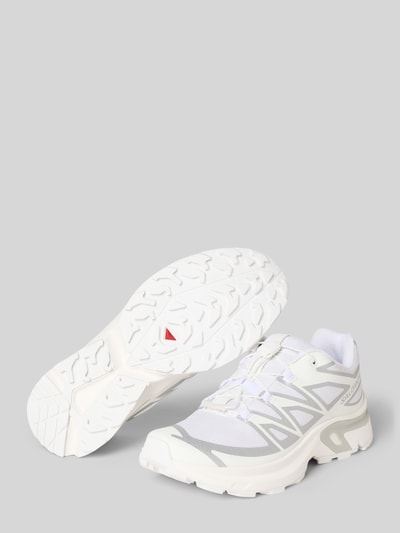 Produktfoto, Sneaker mit Logo-Print von Salomon für Damen, abgerundete Passform, Kontrastbesatz, profilierte Sohle, Absatzhöhe 4 cm, Schafthöhe 6 cm, Schaftweite 7 cm, weiß-graue Farbkombination, strukturierte Texturen.