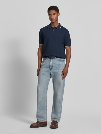Männermodel trägt Regular Fit Poloshirt mit Kontrastkante von Christian Berg Men, Reine Baumwolle, Strukturmuster, Ganzkörperansicht von vorne.