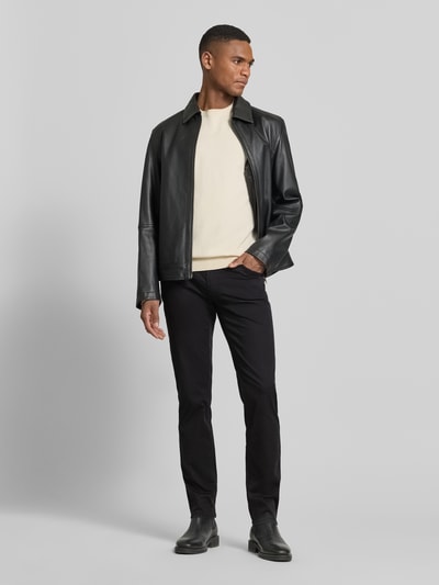 Männermodel trägt Hose mit Eingrifftaschen Modell 'Chuck' von BRAX in Schwarz, Baumwoll-Lyocell-Anteil, Slim-Fit, Ganzkörperansicht von vorne.