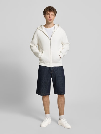 Männermodel trägt Regular Fit Sweatjacke mit Känguru-Tasche von REVIEW in Weiß, Baumwoll-Mix, Reißverschluss, Ganzkörperansicht von vorne.