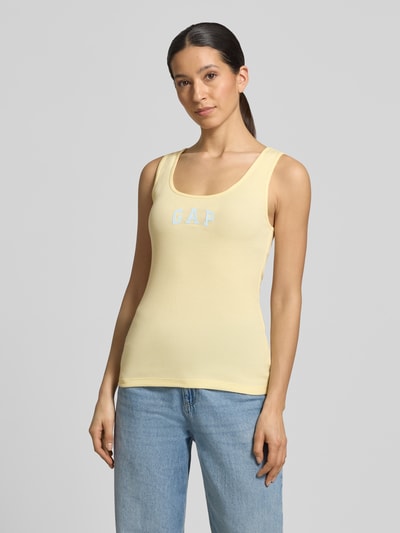 Frauenmodel trägt Slim Fit Top mit Logo-Print von GAP in Gelb aus elastischem Baumwoll-Mix mit Rundhalsausschnitt, Ganzkörperansicht von vorne. Rückenlänge bei Größe S: 58 cm.