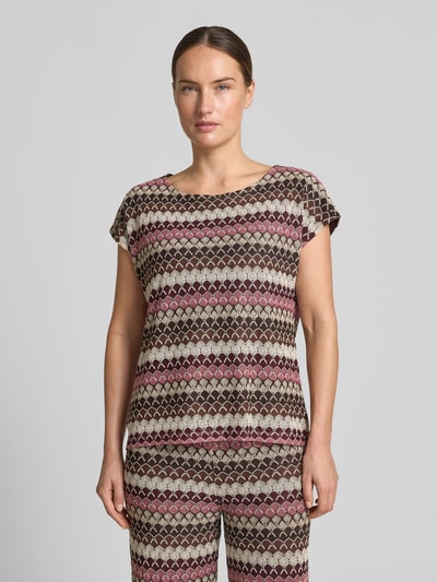 Frauenmodel trägt T-Shirt im Allover-Look mit Rundhalsausschnitt von MORE & MORE in Rosa-Braun-Tönen, Strickshirt, Ganzkörperansicht von vorne.