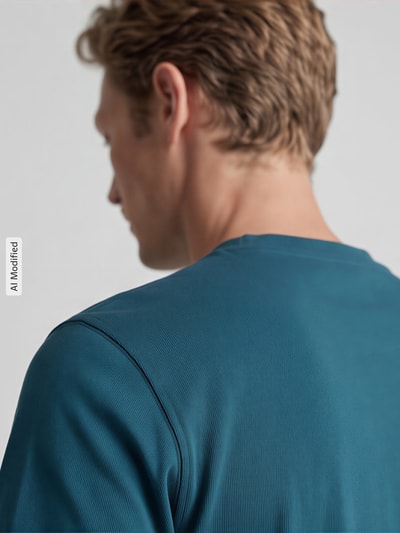 Männermodel trägt T-Shirt mit Rundhalsausschnitt von MCNEAL in Blau, reine Baumwolle, Slim Fit, Rückenlänge 68 cm, Nahaufnahme Rückansicht.
