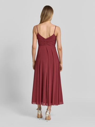 Männermodel trägt Cocktailkleid mit Drapierungen und Spaghettiträgern von Jake*s Cocktail, szyfon, taliowany fason, sukienka midi, drapowania, cienkie ramiączka, długość tyłu w rozmiarze 36: 107 cm, szerokość w rozmiarze 36: 40 cm, bordowy kolor, gładka faktura, całkowita długość z tyłu
