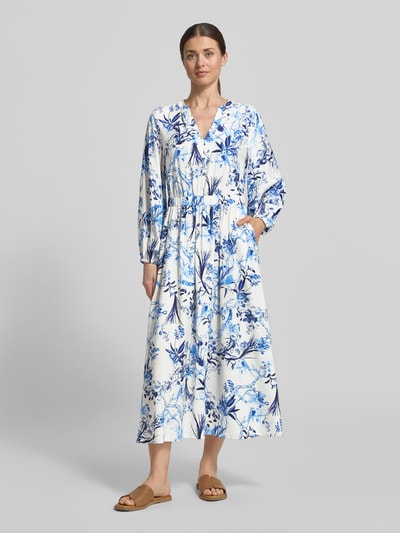 Frauenmodel trägt Midikleid aus Viskose-Mix im Allover-Look von ROBE LÉGÈRE, weiß-blau, A-Linie, V-Ausschnitt, Ganzkörperansicht von vorne.