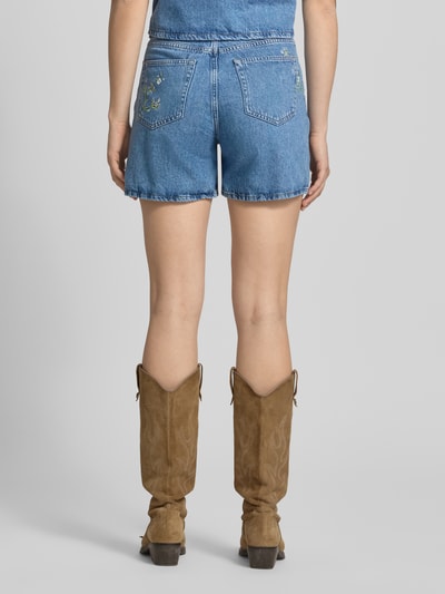 Frauenmodel trägt Regular Fit Jeansshorts aus reiner Baumwolle Modell 'SKY' von Pieces in Denim-Optik mit Stickerei, Nieten, 5-Pocket-Design, Ganzkörperansicht Rückansicht.