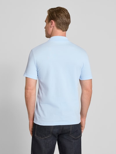 Männermodel trägt Regular Fit Poloshirt aus Baumwoll-Mix von Lacoste, Optik: Unifarben, Logo-Patch, Polokragen, Kurzarm, Ganzkörperansicht Rückansicht.