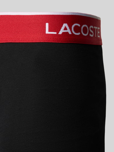 Produktfoto, czarny materiał o gładkiej teksturze, szeroka czerwona guma z logo, Trunk aus Baumwoll-Mix im 5er-Pack von Lacoste, Herren Pant & Trunk