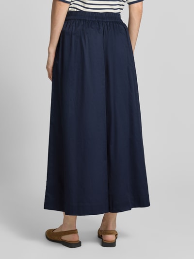 Vrouwenmodel draagt Wide Fit Stoffhose mit Bundfalten van Christian Berg Woman in donkerblauw katoen, elastische taille, verkorte pasvorm, plooien; volledige lichaamsweergave achteraan