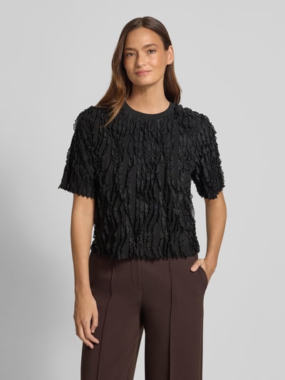 Vrouwenmodel draagt T-shirt met Rüschenbesatz van Jake*s Collection, materiaalmix met stretch, recht model, halfmouw, ronde hals, ruglengte maat S 50 cm, zwart, gestructureerd oppervlak. Ganzkörperansicht van voren.