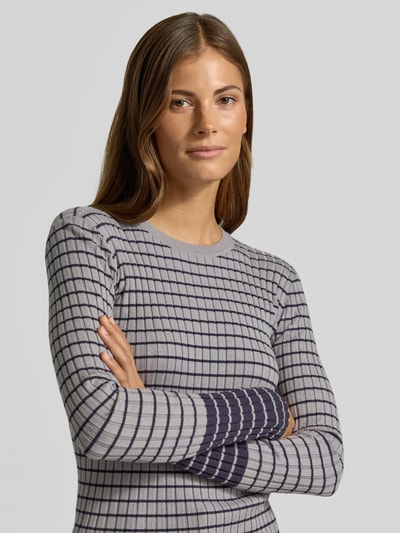 Frauenmodel trägt Skinny Fit Pullover aus Viskose-Mix von Emporio Armani, graue und schwarze Karos, gerippte Optik, Nahaufnahme Oberkörper.