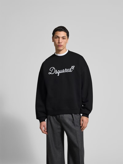 Männermodel trägt Sweatshirt aus reiner Baumwolle von Dsquared2, schwarz mit Label-Detail, Relaxed-Fit, elastische Abschlüsse, Ganzkörperansicht von vorne.