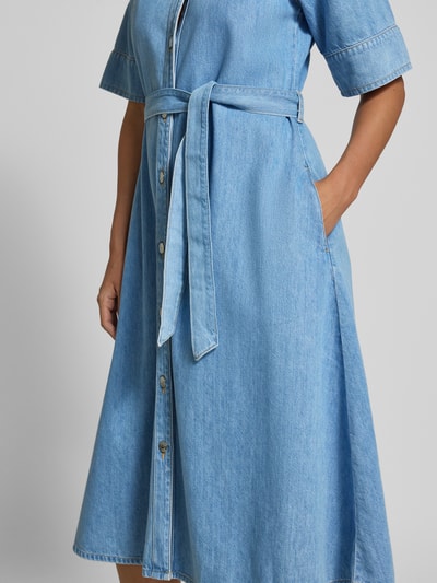 Frauenmodel trägt Midikleid in Denim-Optik mit Lyocell-Anteil von Comma, hellblauer Baumwoll-Lyocell-Mix, halbarm, mit Umlegekragen, durchgehende Knopfleiste, V-Ausschnitt, abnehmbares Taillenband, strukturierte glatte Textur, Ganzkörperansicht von vorne.