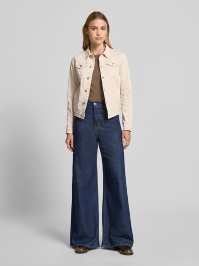 Frauenmodel trägt helle Jeansjacke mit Pattentaschen Modell 'Erna' von Soyaconcept, Baumwoll-Mix mit Stretch-Anteil, Körpernaher-Schnitt, Kentkragen, Knopfleiste, Ganzkörperansicht von vorne.