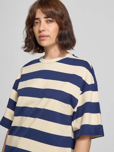 Frauenmodel trägt Oversized T-Shirt aus reiner Baumwolle von s.Oliver RED LABEL mit breiten blauen und beigen Streifen, Nahaufnahme Oberkörper.
