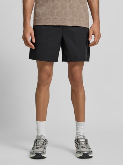 Mężczyzna nosi Relaxed Fit Sportshorts mit elastischem Bund von BOSS Green, czarne, proste linie, matowa faktura, całkowity widok z przodu.