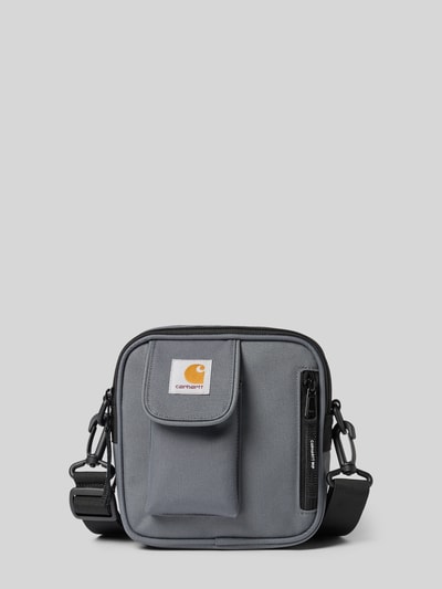 Produktfoto, Crossbody Bag mit Logo-Patch von Carhartt Work In Progress, grau, rechteckige Form, strukturiertes Material, Reißverschlüsse, verstellbarer und abnehmbarer Schulterriemen, 17x18x6 cm, Logo-Patch, Hauptfach mit Teilung.