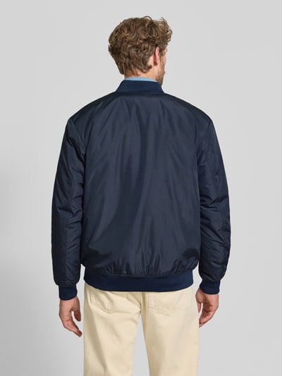 Männermodel trägt dunkelblaue Regular Fit Bomberjacke mit Baseball-Kragen Modell 'CHARLES' von Selected, Herren Bomberjacke, Ganzkörperansicht Rückansicht.