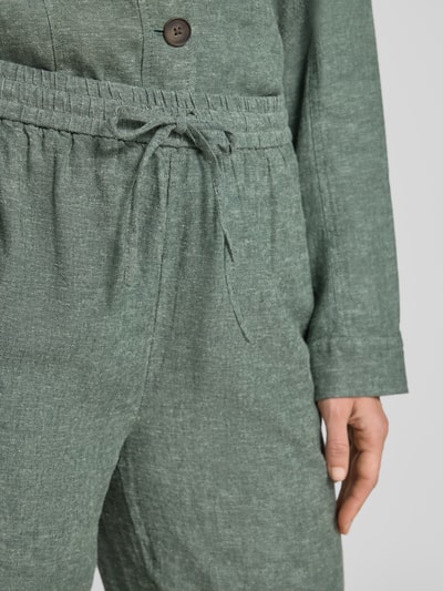 Frauenmodel trägt Leinenhose mit Kordelzug Modell 'Viana Ginia' von MSCH Copenhagen in grünem Leinen-Viskose-Mix, Nahaufnahme Oberkörper.
