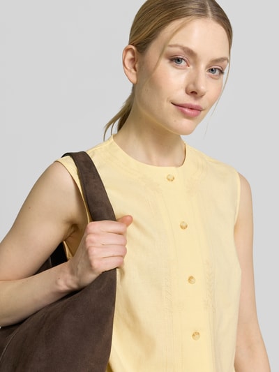Kobiece modelka nosi Blusentop aus Leinen-Viskose-Mix mit Stitchings od JAKE*S STUDIO WOMAN, żółty, krój regular fit, okrągły dekolt, guziki, widoczne przeszycia, kontekst: damski top z lnu i wiskozy, długość tyłu w rozmiarze 36: 50 cm, zbliżenie na górną część ciała.