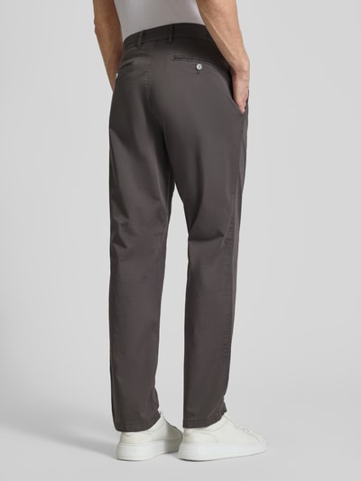 Männermodel trägt spodnie materiałowe Straight Fit Stoffhose mit Lyocell-Anteil Modell 'Everest' von BRAX, elastyczna mieszanka bawełny i lyocellu, kieszenie wpuszczane i z tyłu, kieszonka na monety, zapięcie na guzik i zamek błyskawiczny, kolor ciemnoszary, szerokość w rozmiarze 50: 46 cm, długość wewnętrzna nogawki w rozmiarze 50: 82 cm, widok całej sylwetki z tyłu.
