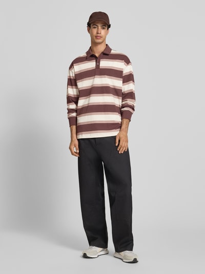 Männermodel trägt Regular Fit Poloshirt mit elastischen Ärmelabschlüssen von PUMA PERFORMANCE aus Reine Baumwolle, Ganzkörperansicht von vorne.