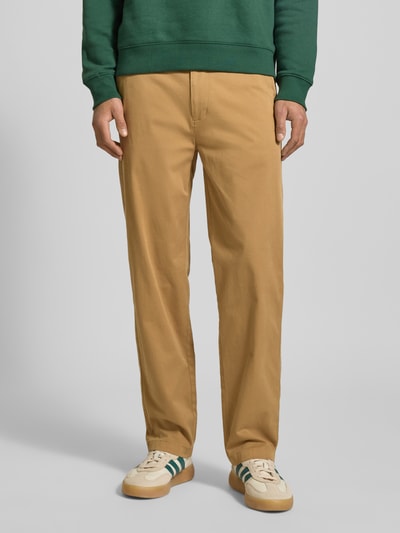 Mężczyzna nosi Tapered Chino aus Baumwoll-Mix Modell 'SONNY' von Tommy Jeans, efekt: jednolity kolor, krój regular fit, wpuszczane kieszenie, szlufki na pasek, zapięcie na guzik i ukryty zamek błyskawiczny, tylna kieszeń i kieszonka na monety, wykończenie: splot twill, mieszanka bawełny, Ganzkörperansicht von vorne.