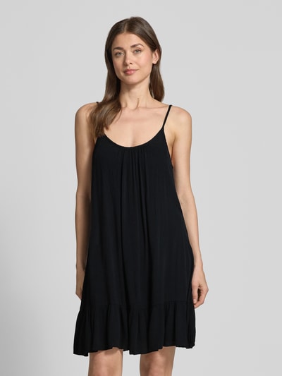 Frauenmodel trägt Minikleid aus Viskose mit tiefem Rückenausschnitt von Shiwi, schwarze A-Linie, feine Textur, verstellbare Träger, Ganzkörperansicht von vorne. Rückenlänge bei Größe S: 68 cm, Brustweite: 35 cm, Modell Ibiza Dress Solid.