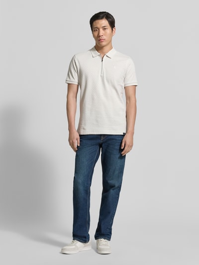 Męskimodel nosi Regular Fit Poloshirt mit kurzem Reißverschluss od Lerros z bawełny, fakturowany wzór, kołnierzyk polo, wyhaftowane logo, naszywka z logo, długość tyłu w rozmiarze M: 72 cm, widok całej sylwetki z przodu.