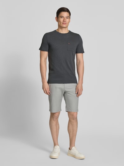 Męski model nosi Regular Fit T-Shirt aus reiner Baumwolle od s.Oliver RED LABEL w kolorze melanżowym, z krótkim rękawem, kieszenią na piersi, wykończenie okrągłym dekoltem, detal z logo, wykonane z czystej bawełny; Ganzkörperansicht von vorne.