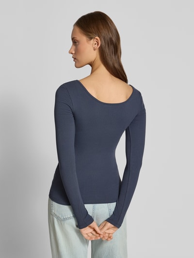 Frauenmodel trägt Slim Fit Langarmshirt aus Baumwoll-Mix Modell 'KITTE' von PIECES, unifarben, Rippstruktur, Ganzkörperansicht Rückansicht.