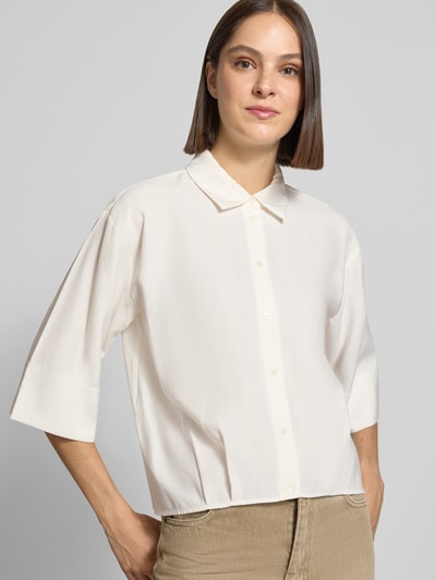 Frauenmodel trägt Loose Fit Kurzarmbluse aus Modal-Mix Modell 'Fotori' von OPUS, cremefarben, glatte Textur, Nahaufnahme Oberkörper, Damen Kurzarmbluse von OPUS.