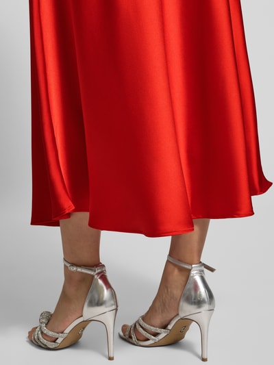 Frauenmodel trägt Maxirock mit elastischem Bund Modell 'Fabiola' von GUIDO MARIA KRETSCHMER WOMAN im leuchtenden Rot, Material-Mix mit Stretch-Anteil, lockerer Schnitt, Detailaufnahme Unterschenkel und Saum.