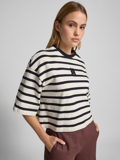 Kobiece modelka nosi Cropped T-Shirt mit Motiv-Stitching od Smith and Soul, bawełna, krój loose fit, okrągły dekolt, długość tyłu 52 cm, widok z przodu zbliżenie na górną część ciała