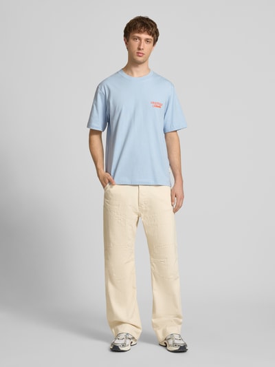 Männermodel trägt T-Shirt mit Label-Print von Jack & Jones, hellblau, reine Baumwolle, Relaxed Fit, Rundhalsausschnitt, Ganzkörperansicht von vorne