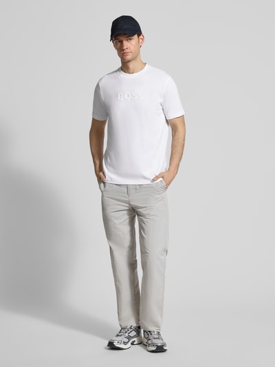 Männermodel trägt Regular Fit T-Shirt aus reiner Baumwolle Modell 'TS_TERRACE' von BOSS Green in Weiß, Ganzkörperansicht von vorne.