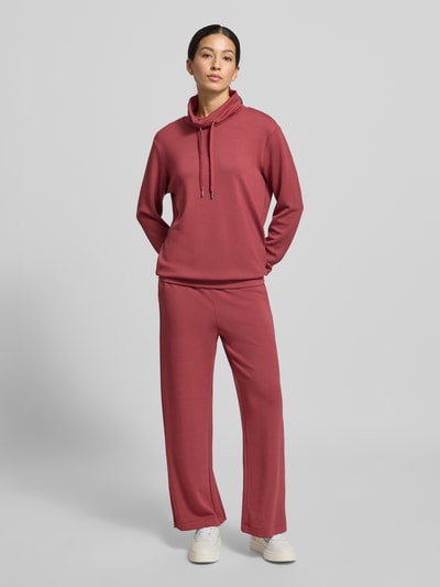 Frauenmodel trägt Sweatshirt mit Tunnelzug Modell 'Banu' von Soyaconcept in Dunkelrosa, lockerer Schnitt, glatte Textur, Ganzkörperansicht von vorne.
