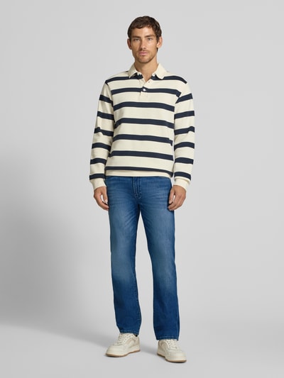 Männermodel trägt Relaxed Fit Jeans aus Baumwoll-Mix Modell 'Clint' von Brax, mittleres Blau, Herren Wide & Loose Fit Jeans, Ganzkörperansicht von vorne.