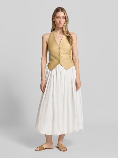 Frauenmodel trägt Weste mit Neckholder und V-Ausschnitt von Comma, Material-Mix mit Leinen-Anteil, taillierter Schnitt, Knopfleiste, Ganzkörperansicht von vorne.