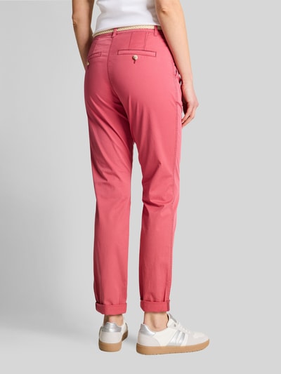 Frauenmodel trägt Slim Fit Chino aus Baumwoll-Mix von Tom Tailor in Rosa mit Gürtelschlaufen, Kontrastnähten und Umschlag, Ganzkörperansicht Rückansicht.