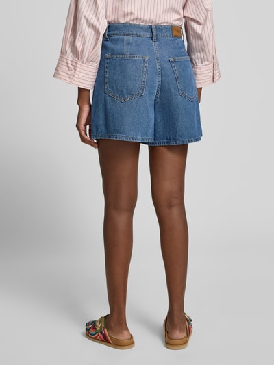 Frauenmodel trägt Jeansshorts mit Eingrifftaschen Modell 'GEMMA' von YAS in Blau, Reine Baumwolle, Regular-Fit, Ganzkörperansicht Rückansicht, Bundweite Größe 36: 37 cm, Innenbeinlänge Größe 36: 41 cm.