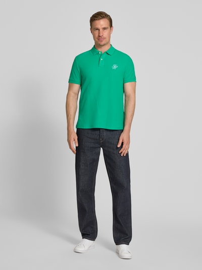 Männermodel trägt Regular Fit Poloshirt aus reiner Baumwolle von Tommy Hilfiger, Optik: Unifarben, Ganzkörperansicht von vorne.