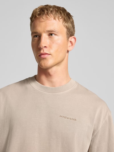 Männermodel trägt Oversized T-Shirt mit Label-Stitching von Pegador aus reiner Baumwolle, gerippter Rundhalsausschnitt, Nahaufnahme Oberkörper.