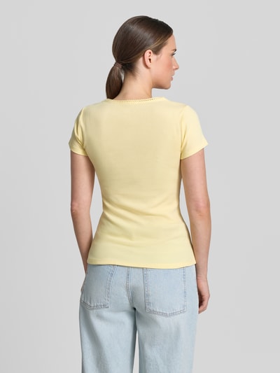 Frauenmodel trägt T-Shirt mit Logo-Stitching von GAP in Gelb aus Baumwoll-Mix mit Stretch-Anteil, körpernahe Passform, Rundhalsausschnitt, Rückenlänge bei Größe S: 57 cm, Ganzkörperansicht Rückansicht.