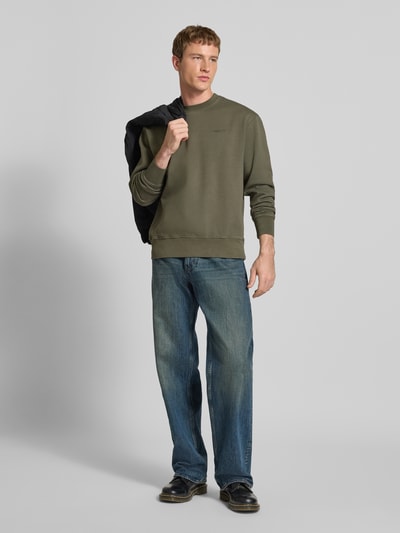 Männermodel trägt Sweatshirt mit Rundhalsausschnitt und Label-Stitching von Levi's®, olivgrün, reine Baumwolle, Regular Fit, Ganzkörperansicht von vorne.