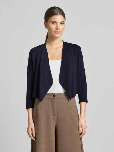 Frauenmodel trägt Strickjacke in offener Passform mit 3/4-Arm von comma, dunkelblau, glatte Textur, Ganzkörperansicht von vorne.